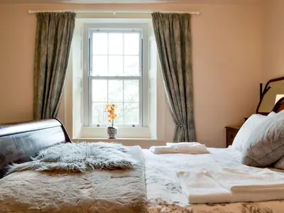 a bedroom with a bed and a window at The Old Vicarage in Westward