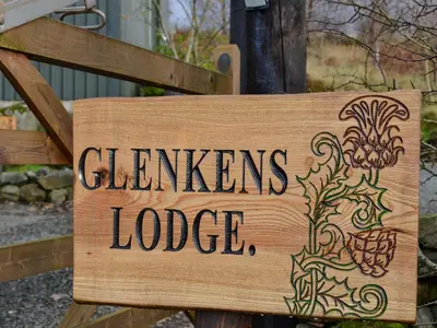 a wooden sign that reads gardens lodges lodge at Glenkens Lodge in Dalry