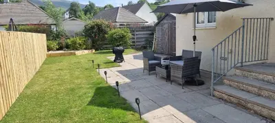 a person standing in a yard with an umbrella at Plum Cottage in Keswick