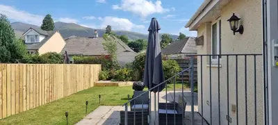 an umbrella sitting on the side of a house at Plum Cottage in Keswick