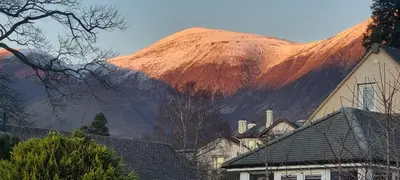 a mountain in the background with houses and a building at Plum Cottage in Keswick