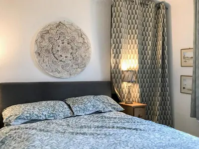 a bedroom with a bed and a picture on the wall at Kitty's Cottage in Girvan