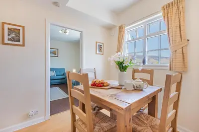 a dining room with a wooden table with fruit on it at Cottage 9 Old Farmhouse Braithwaite in Keswick