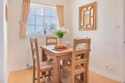 a dining room table with chairs and a bowl of fruit at Cottage 9 Old Farmhouse Braithwaite in Keswick