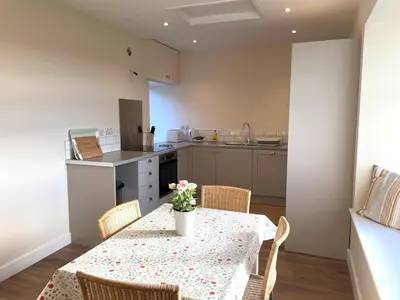 a kitchen with a table with a vase of flowers on it at Beautiful 5BR Rural Cottage with Outstanding Views - Pass the Keys in Castle Douglas