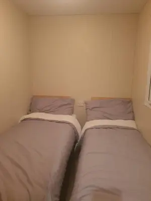 two twin beds in a small room withermottermottermottermott at Loch Heron View in Newton Stewart
