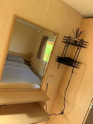 a small bedroom with a mirror on the wall at Loch Heron View in Newton Stewart