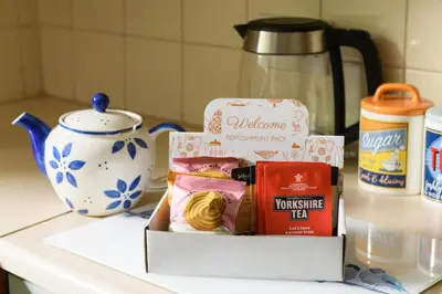a box of food sitting on a counter next to a teapot at Finest Retreats - The Cottage at Greystoke in Greystoke