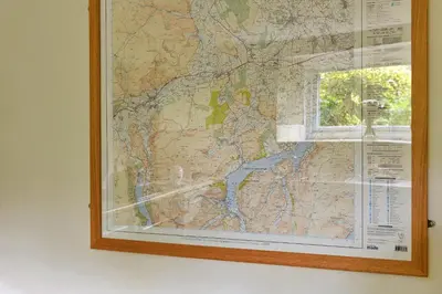 a map hanging on a wall next to a window at Finest Retreats - The Cottage at Greystoke in Greystoke