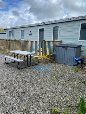 a picnic table and a bench in front of a house at Trekkers Rest, Brigham, Cockermouth, Cumbria in Cockermouth