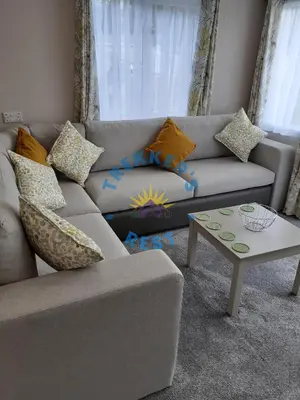 a living room with a couch and a table at Trekkers Rest, Brigham, Cockermouth, Cumbria in Cockermouth