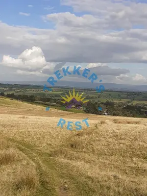 a field with a sign in the middle of a field at Trekkers Rest, Brigham, Cockermouth, Cumbria in Cockermouth