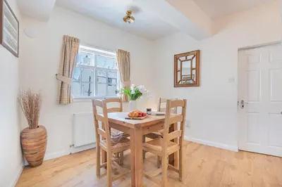 a dining room with a wooden table and chairs at Cottage 8 Old Farmhouse braithwaite in Keswick