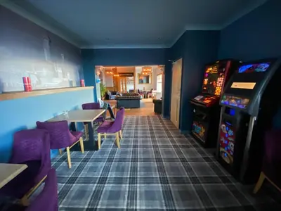 a dining room with a table and a video game at The Calder House Hotel in Seascale