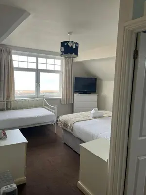 a hotel room with two beds and a window at The Calder House Hotel in Seascale