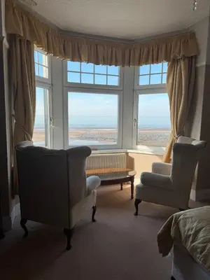 a living room with two chairs and a large window at The Calder House Hotel in Seascale