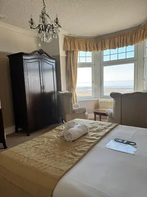 a bedroom with a bed and a large window at The Calder House Hotel in Seascale