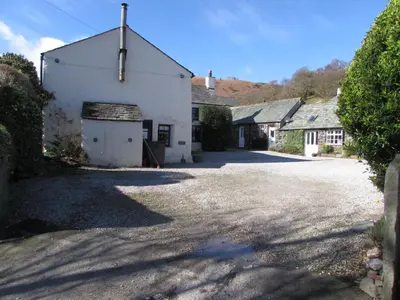 a large white building with a garage in a driveway at Cottage 6 Studio Mews in Keswick