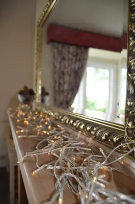a mirror sitting on top of a wooden table at Glaisters Farmhouse in Castle Douglas