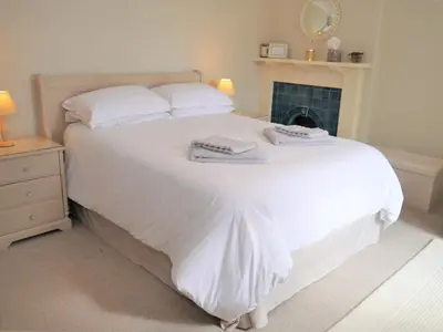 a bedroom with a white bed with towels on it at Glaisters Farmhouse in Castle Douglas