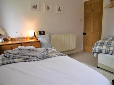 a bedroom with a bed and a table with a lamp at Glaisters Farmhouse in Castle Douglas