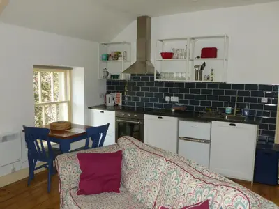 a living room with a couch and a kitchen at The Old Map Shop in Wigton