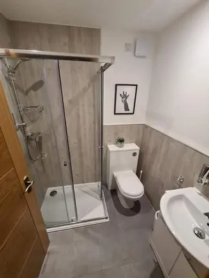 a bathroom with a shower and a toilet and a sink at Royal Oak Braithwaite in Keswick