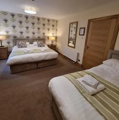 a hotel room with two beds and two lamps at Royal Oak Braithwaite in Keswick