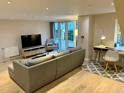 a living room with a couch and a television at The Workshop, Bridge House in Laxey