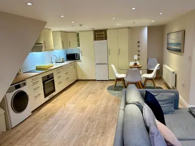 a kitchen and living room with a couch and a table at The Workshop, Bridge House in Laxey