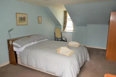 a bedroom with a bed in a room at Grooms Cottage in Carsethorn