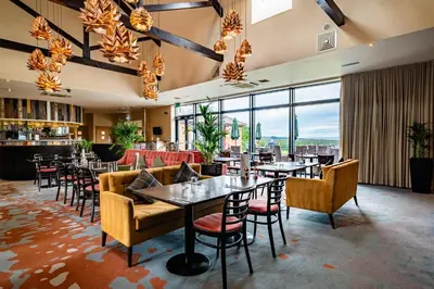 a restaurant with tables and chairs and large windows at Bowscale Suite in Penruddock