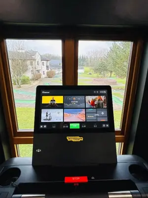 a laptop computer sitting on a treadmill in front of a window at Bowscale Suite in Penruddock