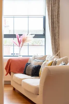 a white couch in a living room with a window at No27 The Barclay - Donnini Apartments in Kilmarnock