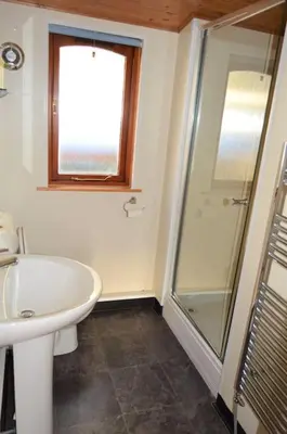 a bathroom with a sink and a glass shower at Woolpack Lodge in Holmrook