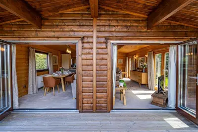 an open door of a log cabin with a dining room at Screel View in Kippford