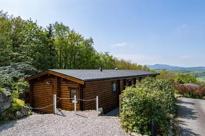 a small cabin with a roof on a gravel driveway at Screel View in Kippford