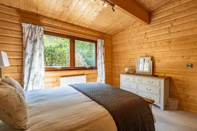 a bedroom with a bed and a window in a log cabin at Screel View in Kippford