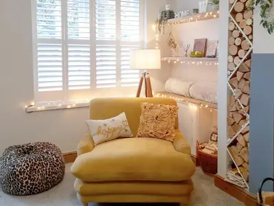 a yellow chair in a living room with a lamp at Willow Cottage in Cockermouth