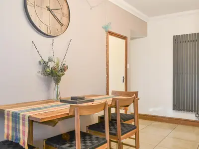 a dining room with a table and a clock on the wall at Willow Cottage in Cockermouth