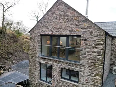 a brick house with large windows on the side of it at Waterfall in Castle Douglas