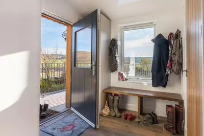 a room with a door and a bench and a window at Grobdale Byre in Gatehouse of Fleet