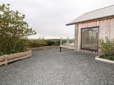 a house with a gravel patio next to a building at The Lodge in Stranraer