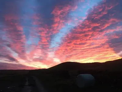 a sunset with a colorful sky with clouds at Dairy Cottage in Gatehouse of Fleet