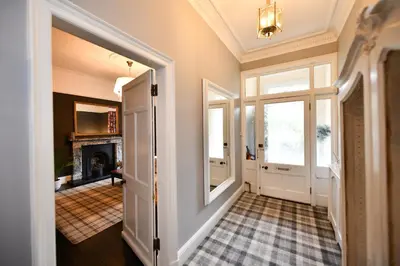 a hallway with a door leading to a living room at The Old Manse in Ayr