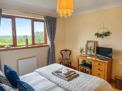 a bedroom with a bed and a desk with a television at Trelaw - Uk41532 in Cumnock