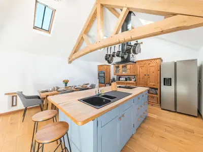a kitchen with blue cabinets and a stainless steel refrigerator at Swallow Barn in Cockermouth