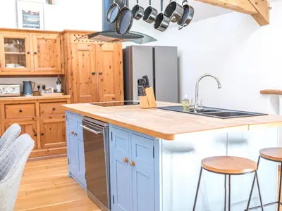 a kitchen with blue cabinets and a counter top at Swallow Barn in Cockermouth