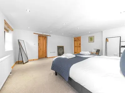 a white bedroom with a large bed in it at Swallow Barn in Cockermouth
