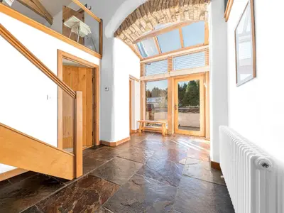 an empty room with a staircase and a large window at Swallow Barn in Cockermouth